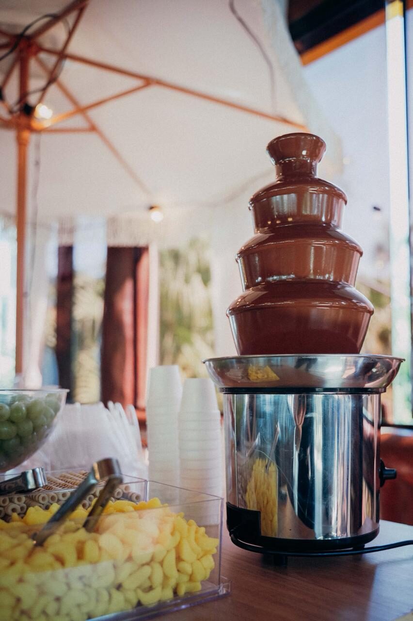 Cascata de chocolate escorrendo sobre a mesa de doces