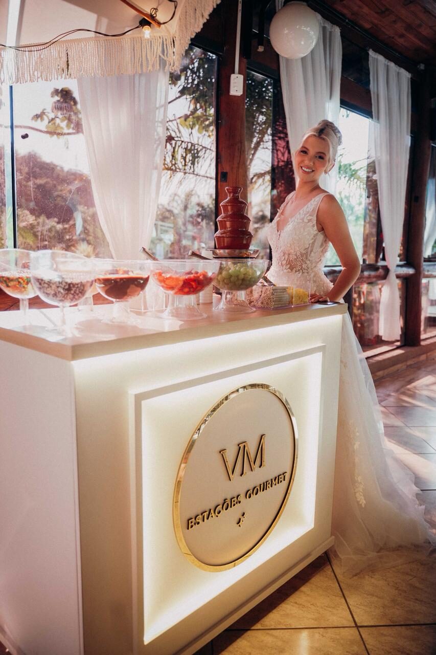 Noiva sorrindo ao lado da estação gourmet com cascata de chocolate